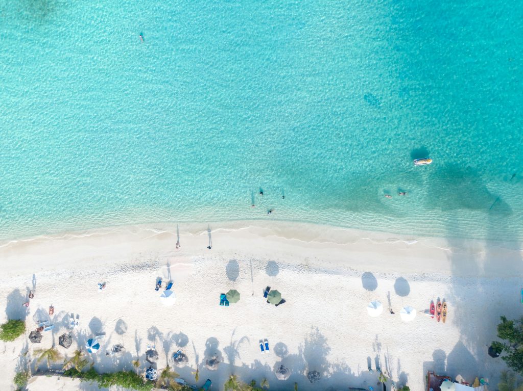 A stunning aerial view of a tropical beach with white sand and clear turquoise water, perfect for relaxation.